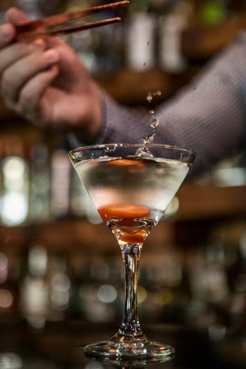 Copa de coctel con tequila servida en una barra